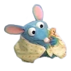 The character Tutter Mouse from the series Bear in the Big Blue House. He is a small blue mouse wrapped in a blanket holding an even smaller cat stuffed animal. He has a nervous expression.