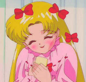 The character Usagi from the series Sailor Moon. She is in cute pink pajamas with red ribbons in her hair. She is blushing sweetly holding a phone close to her chest because she just spoke to her boyfriend.